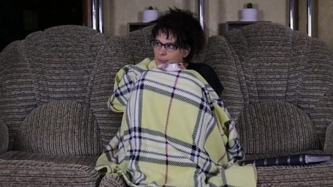 A woman in a fever is sick lying on the couch Stock Footage