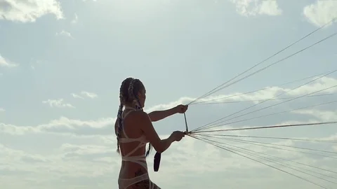 Woman is fighting with the strength of the wind, pulling white canopy in daytime Stock Footage 84558985