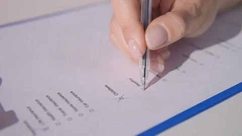 Woman fill out a questionnaire, putting check marks Stock Footage