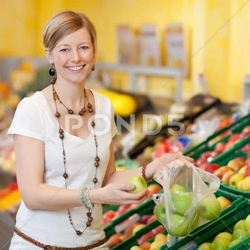 Woman filling plastic bag with apples in grocery store Stock Photos