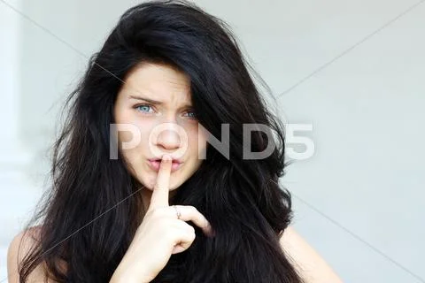 Woman with a finger on her lips showing to keep silence Stock Photos