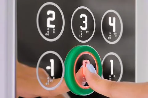 Woman finger pressing elevator ground floor button Stockfoto's