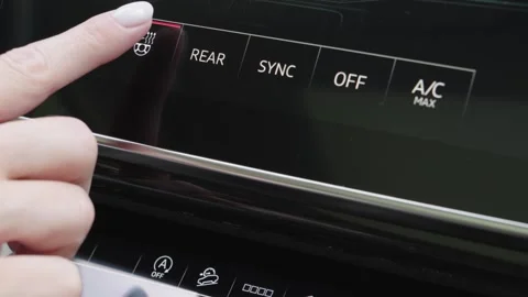 Woman finger pressing touchscreen button to activate heated steering wheel in Stock Footage 339334834