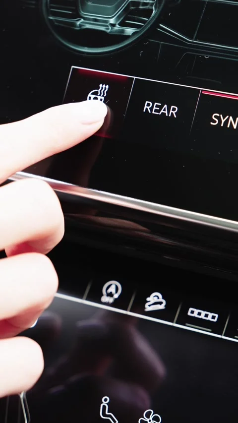 Woman finger pressing touchscreen button to activate heated steering wheel in Stock Footage 339335109