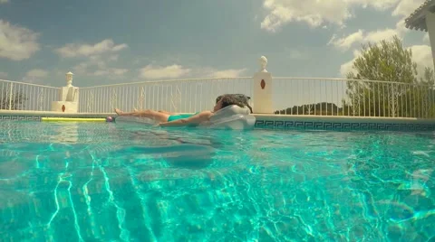 Woman floating in pool (camera drops below water surface) 스톡 동영상 56206459