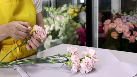 Woman florist assembles a composition of pink flowers, small business - flower 動画素材 156262402