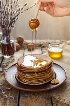 Woman flowing maple syrup on stack of traditional pancakes Stock Photos