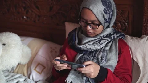Woman focus using phone on bed, playing games or watching online video Stock Footage 143894125