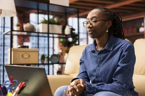 Woman focused on a virtual workshop to learn new skills from her apartment Stock Photos