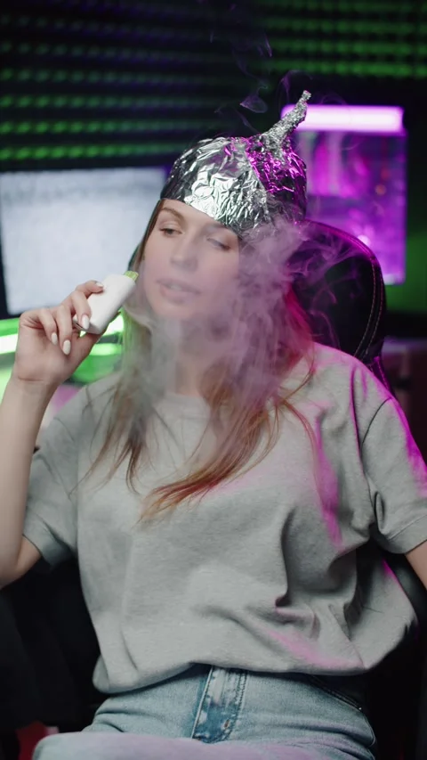 Woman in Foil Hat Vaping an E-Cigarette Vídeos de archivo 322897457