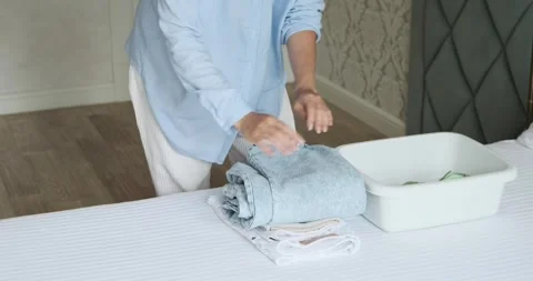Woman Folding Clean Clothes into Stack Stock Footage 250036612