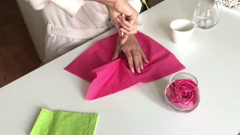 A woman folds a flower from a paper napkin. With a fork. She puts it in a cup Stock Footage
