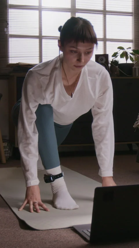 Woman Following Yoga Tutorial, Practicing on Mat in Bedroom Under House Arrest Stock Footage 323787663
