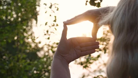 Woman framing setting sun with hands at summer sunset light Stock-Footage 316785253