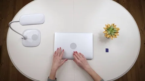 Woman freelance inserts a flash card into a laptop and works on it. Top view Stock Footage 84819309
