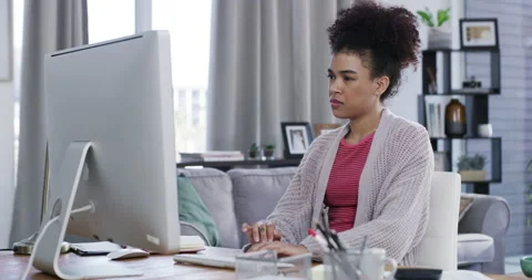 Woman freelance worker on a computer thinking and typing while contemplating an Stock Footage 225519250