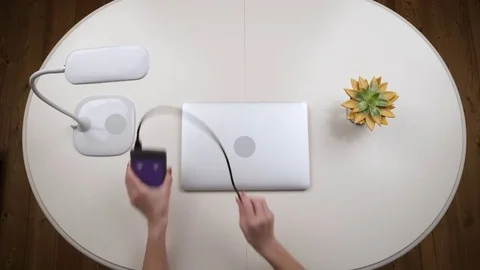Woman freelancer connected an external hard drive to the laptop and works on it Stock Footage 84823020