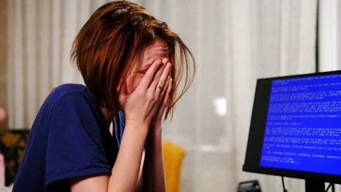 Woman is frustrated in front of blue computer screen at home. Breakdown, viru Stock Footage 169993253