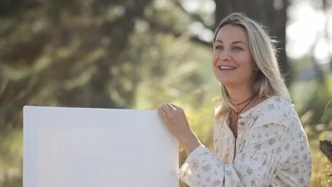 A woman fully engaged in the beautiful process of creating art outdoors on a Stock Footage 304826563