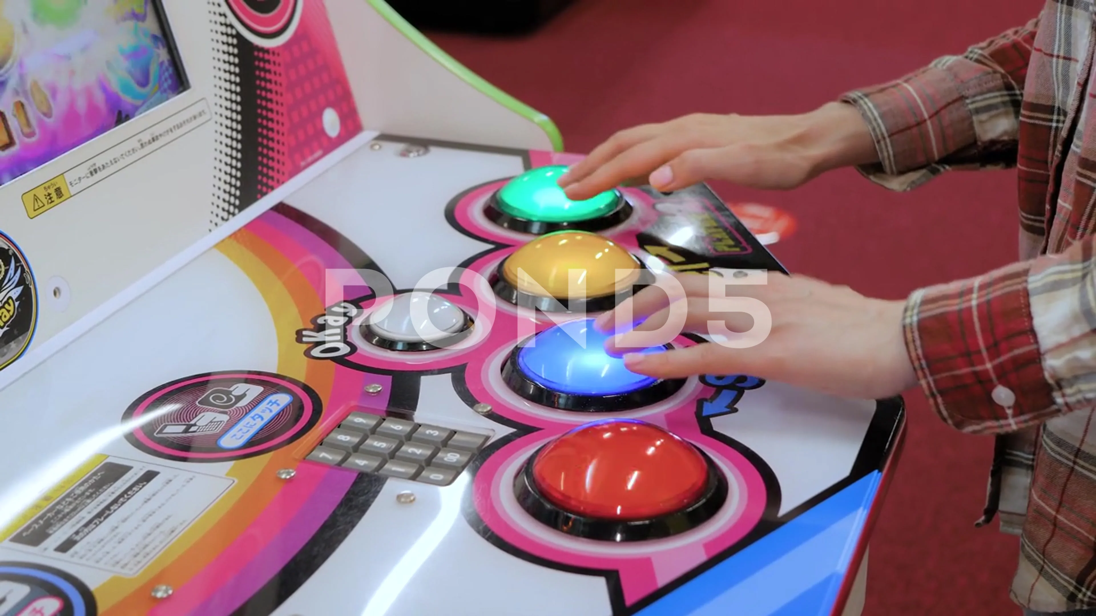 Woman gamer playing Japanese arcade rhythm game machine close up