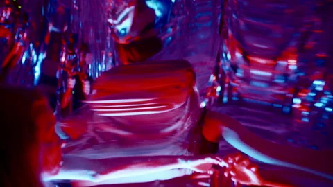 Woman Gazing at Transforming Reflections in Distorting Mirror under Neon Light Stock Footage 306981815