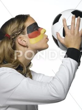 Woman with German flag painted on face and wearing German football dress kissing Stock Photos