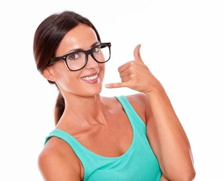 Woman gesturing calling on the phone while smiling a toothy smile and looking Stock Photos