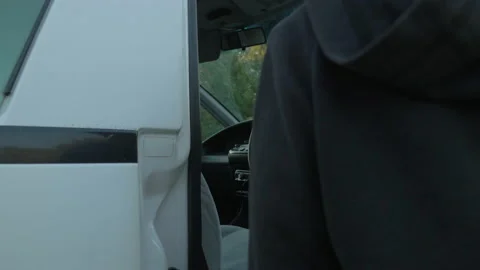 A woman gets into her van before hitting the road again, in New Zealand Stock Footage 220031992