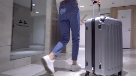 Woman gets out of elevator in corridor of modern hotel, traveling luggage, Stock Footage 171607970