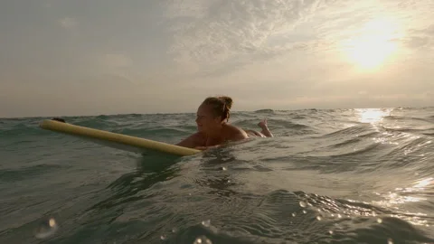Woman gets pleasure when drifting on waves while lying on surfboard Stock Footage 220053027