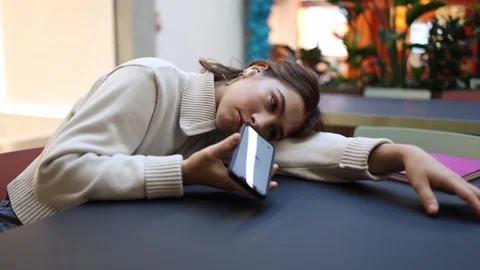 Woman gets sleepy while talking to artificial intelligence on phone indoors Stock Footage 323738727