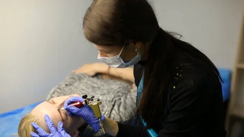 Woman getting eyebrow tattoo Stock Footage