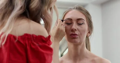 Woman is getting her eyebrows done by a makeup artist. Stock Footage 307574215