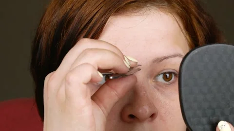 A woman getting her eyebrows threaded.Using metal tweezers. 스톡 동영상 133569611