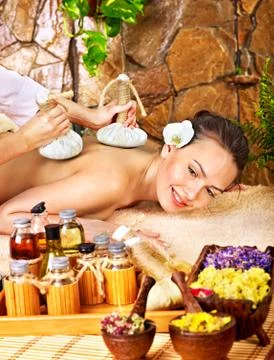 Woman getting thai herbal compress massage Stock Photos