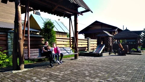 Woman with girls swinging at yard Stock Footage