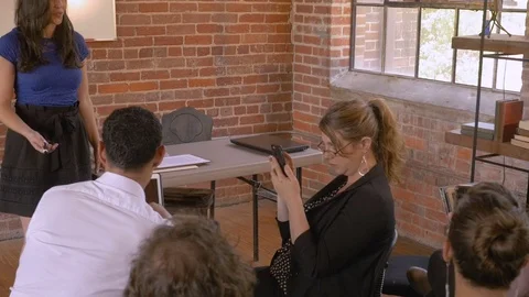 Woman giving a presentation while audience ignores her all using technology Stock Footage 78937151