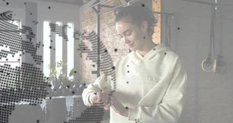 Woman glancing tapping watch checking tech alerts in loft dotted map code blocks Stock Footage 330652610