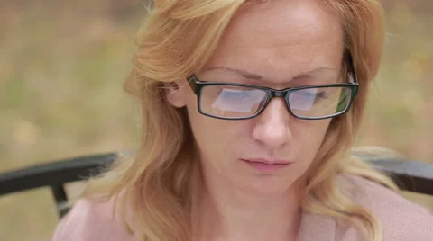 Woman with glasses reading a book. close-up. reflected in the lenses of the book Stock Footage
