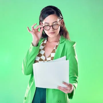 Woman in glasses reading paper isolated on green background for fashion design Stock Photos