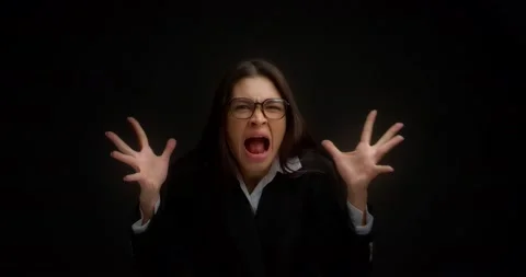 Woman with glasses, shouting with an aggressive expression and raised hands. Stock Footage 171560731