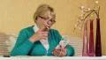 Woman in glasses with smartphone sits at a table and smokes a cigarette HD Footage