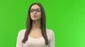 The woman in glasses stand on the green screen background 4k or 4k+ Resolution
