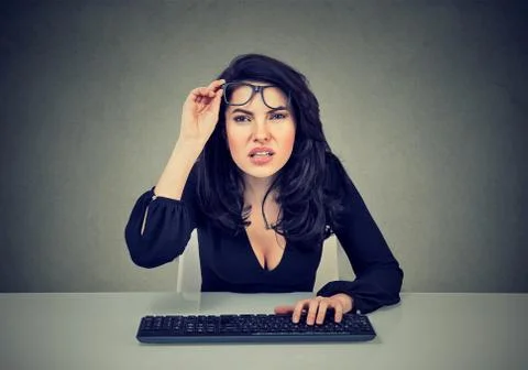 Woman in glasses using computer has vision problems Stock Photos