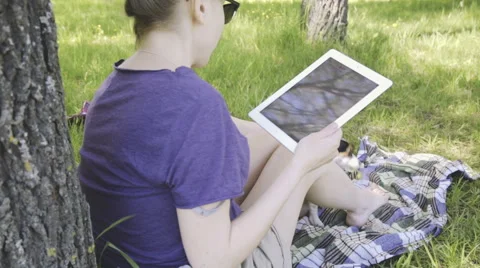 Woman in glasses using tablet pc in the park. Stock Footage 50542251