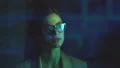 The woman in glasses walking in a dark room near a display. slow motion 4k or 4k+ Resolution