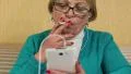 Woman in glasses with white smartphone smoking a cigarette HD Footage
