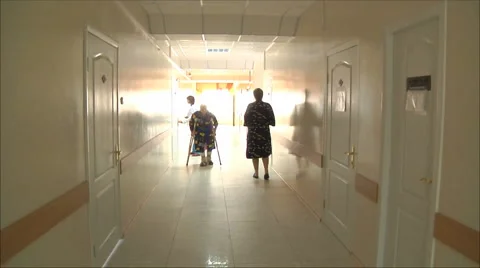 Woman goes to the hospital corridor on the crutches Stock Footage