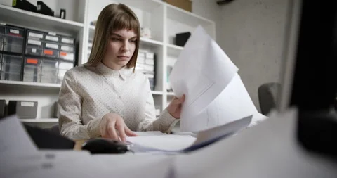 A woman goes through the documents on the table, then freaks out and throws them Stock-Footage 185371091
