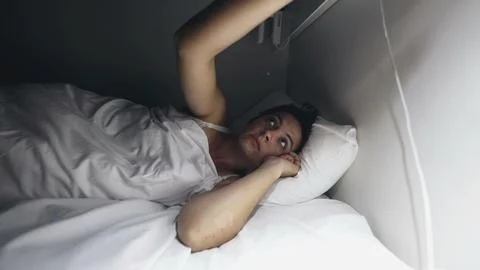 Woman going to sleep shutting off nightlamp. Person turns OFF light Stock Photos